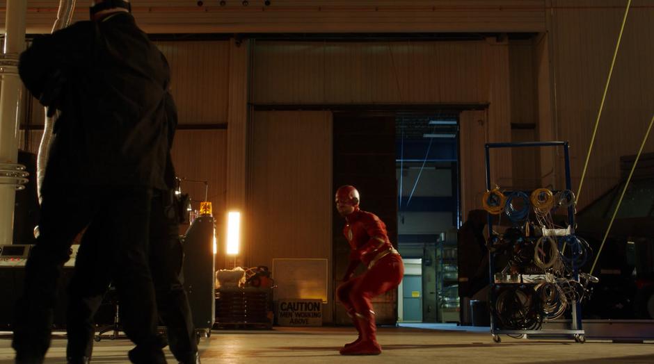 Oliver as the Flash comes to a stop in front of the thieves.