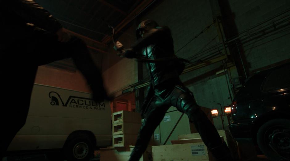 Oliver fights with one of the goons while wearing the Green Arrow outfit.