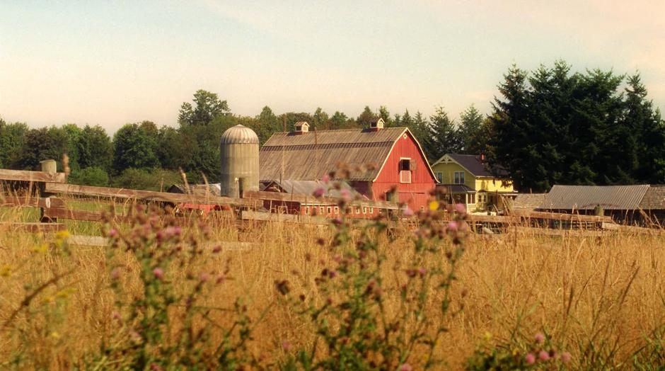 Establishing shot of the farm across a field.