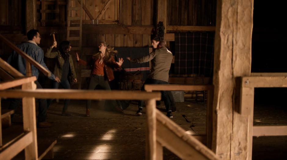 Kara gets between Lois and Barry & Oliver as Lois threatens them with a hammer after they breached into the barn.