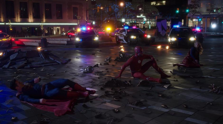 Clark, Oliver, and Kara sit up after being thrown to the ground when Amazo exploded.