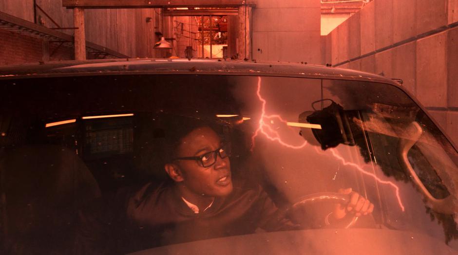 Curtis looks up at the lightning through the windshield of his van.