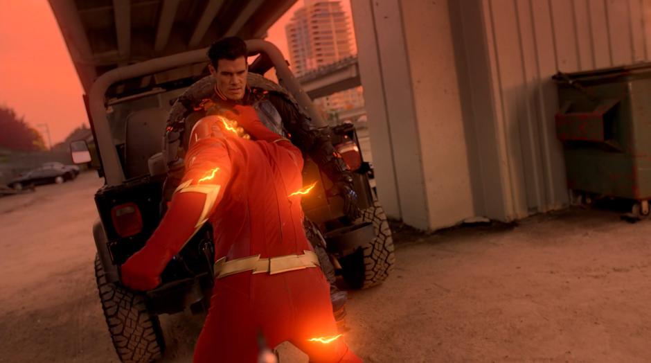 Oliver as the Flash throws Kane Wolfman against a parked car.