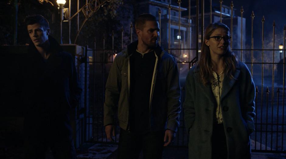 Kara discusses the plan with Barry and Oliver outside the gate.