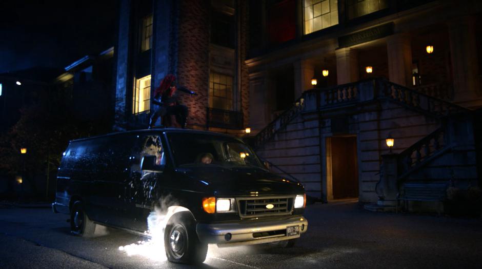 Batwoman lands on the roof of the van that the patients are trying to use to escape.