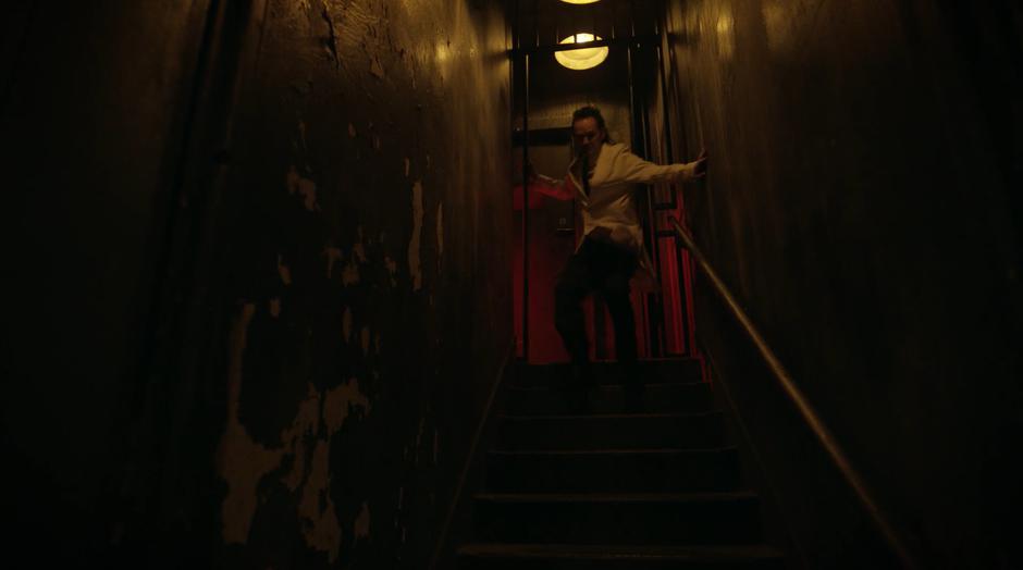 Dr. Deegan runs down the stairs into the basement of the asylum.