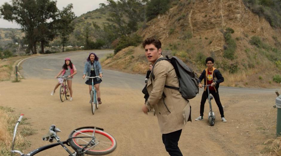 Chase watches Mike on a Bike tackled by Old Lace as Molly, Gert, Nico, and Alex stop on their bikes behind him.