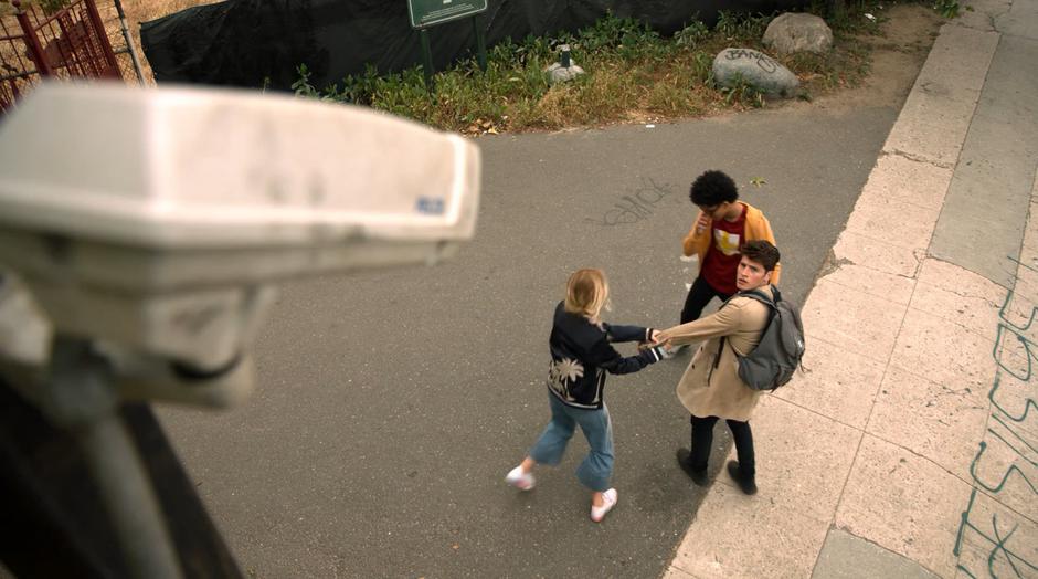 Karolina pulls Chase and Alex back when she realizes their is a security camera watching them.