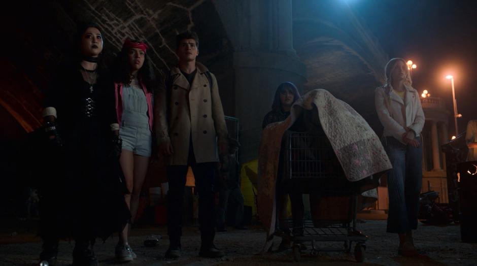 Nico, Molly, Chase, Gert, and Karolina look around the camp as they enter during the night.