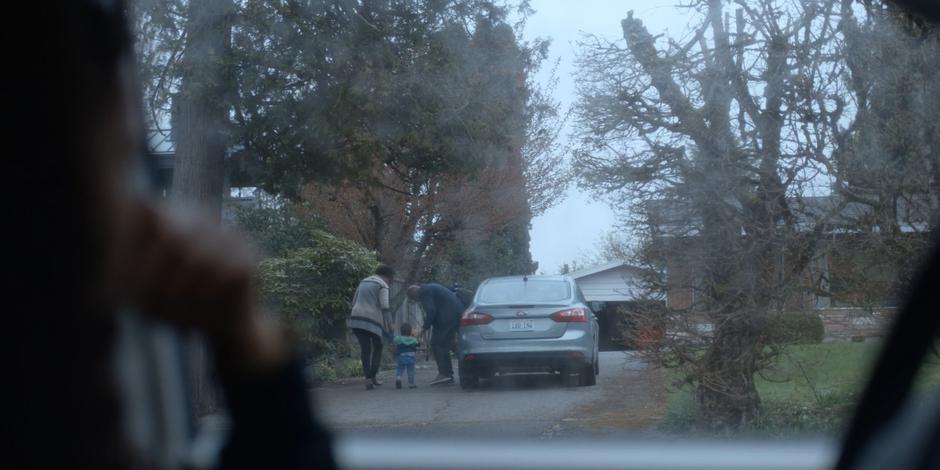 Carly watches from her car as Jeffrey's new foster parents walk him to their house after first bringing him home.