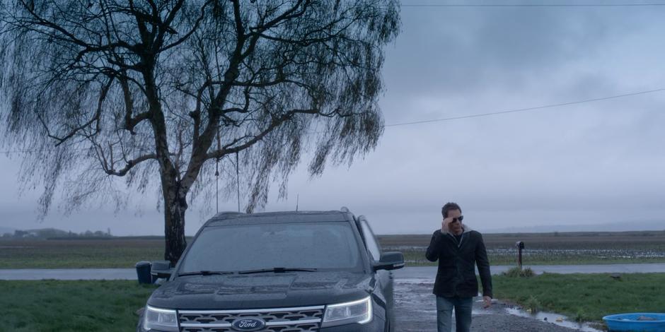 Grant takes off his sunglasses as he walks away from his car.