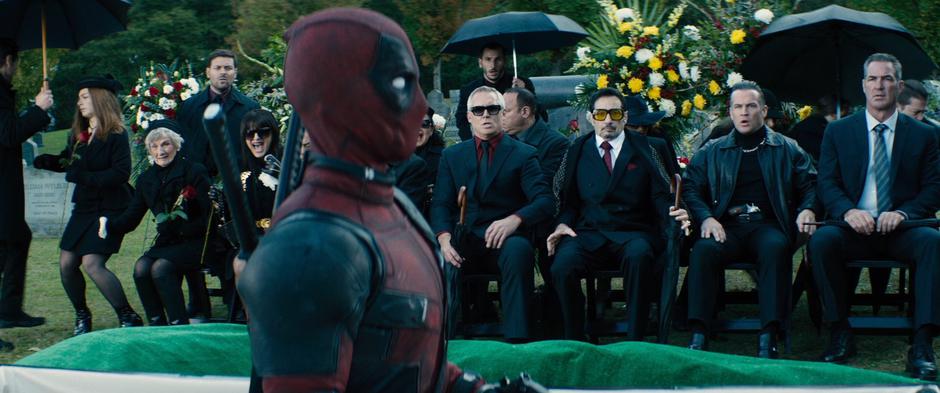 Wade rises from the grave in front of the mourners.