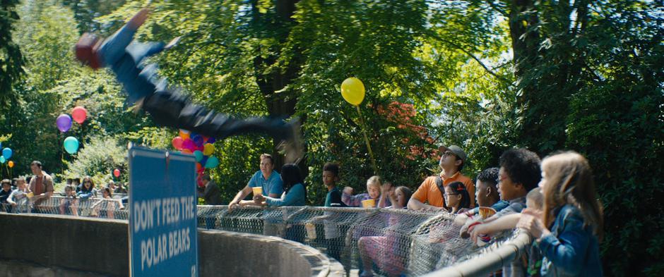 Kids stand at the fence while Wade leaps into the polar bear enclosure.