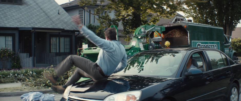 Peter slides over the front of a car to rescue Zeitgeist from a wood chipper.