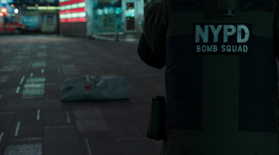 A member of the bomb square walks up to the abandoned duffle bag.