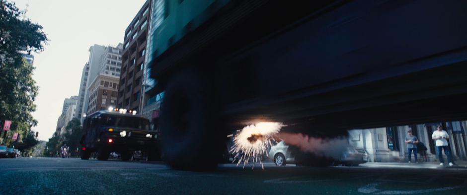Cable's shot impacts beneath the convoy truck and bounces towards the humvee following close behind.