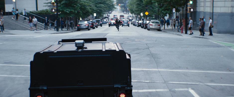 The leading humvee approaches one side of the intersection while Cable raises his gun from the other side.