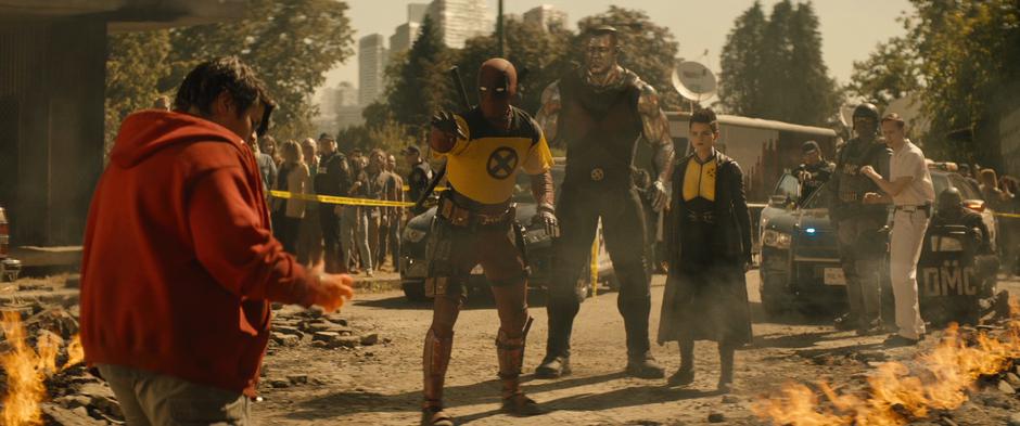 Wade puts out his hand to try and calm Russell while standing in front of Colossus and Negasonic Teenage Warhead.