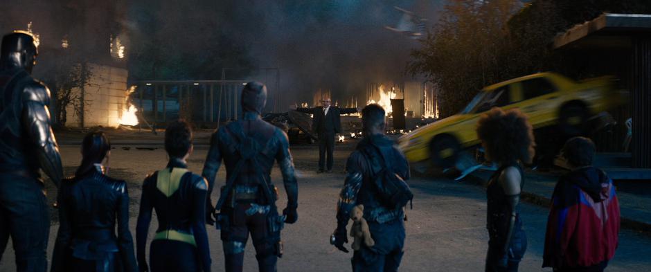 Colossus, Yukio, Negasonic Teenage Warhead, Wade, Cable, Domino, and Russell watch as Dopinder drives his taxi over a hill and into the headmaster.