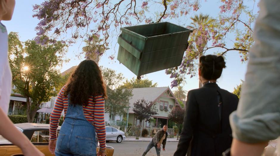 Molly and Nico look up as the dumpster flies towards them thrown by Topher.