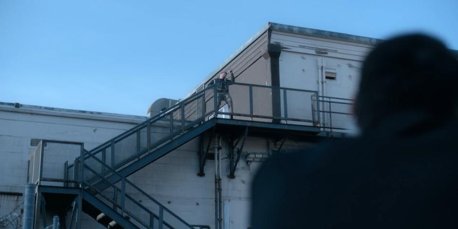 One of 001's recovery team shoots a Faction guard standing on the rooftop.