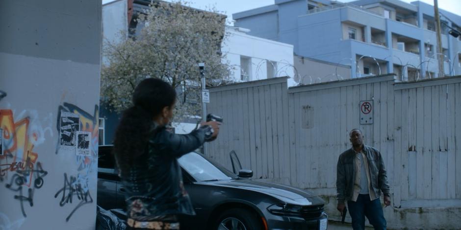 Carly points her gun at Jeff as he holds his down at the ground.