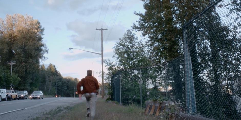 Trevor runs down the side of the road towards the lab.