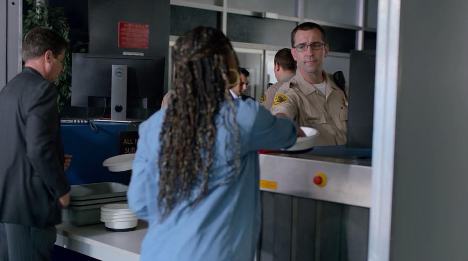 Livvie puts her keys into a tray before passing through the metal detector.