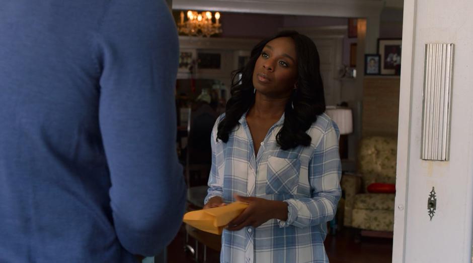 Tamar looks up at Geoffrey after he hands her the envelope of money.
