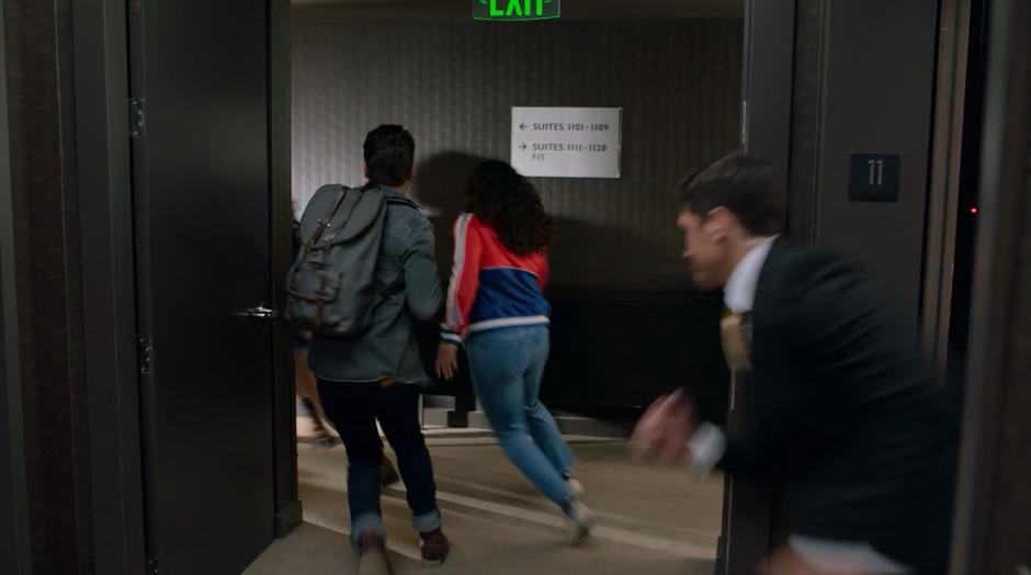 Chase, Molly, and the others turn and run as a security guard runs out of the elevator towards them.