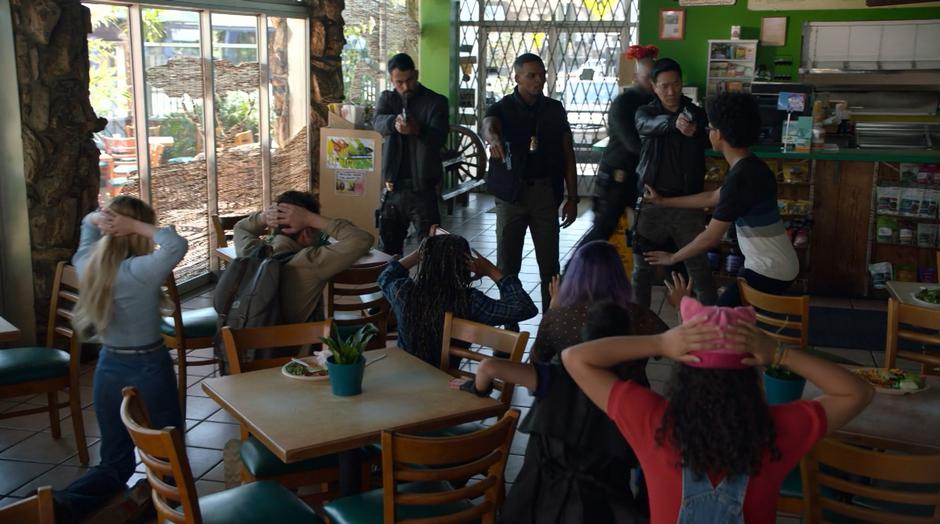 AWOL and his corrupt cop buddies point their guns at Livvie and the other kids and have them kneel on the floor.