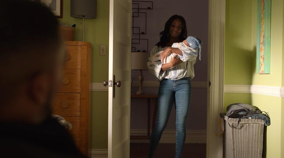 Tamar walks into the bedroom holding her newborn to where AWOL is waiting.