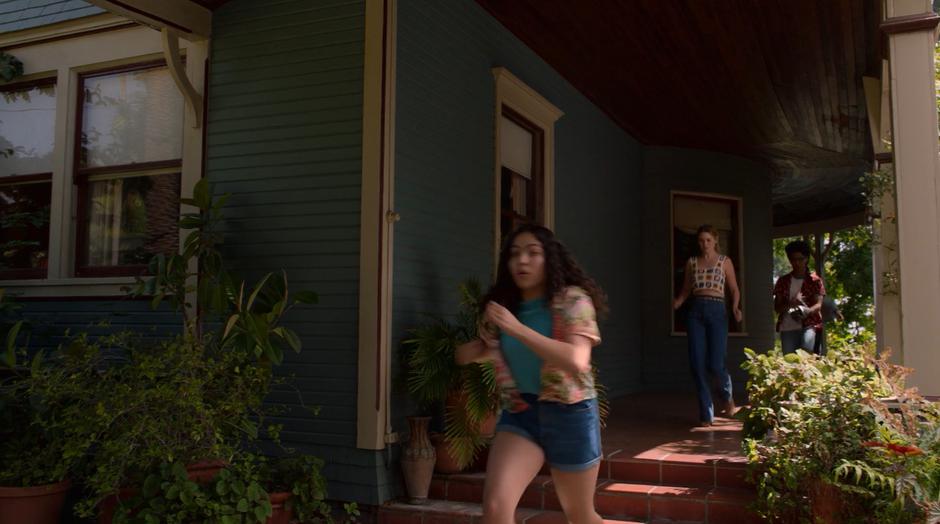 Molly, Karolina, and Alex run out of the house towards their car.