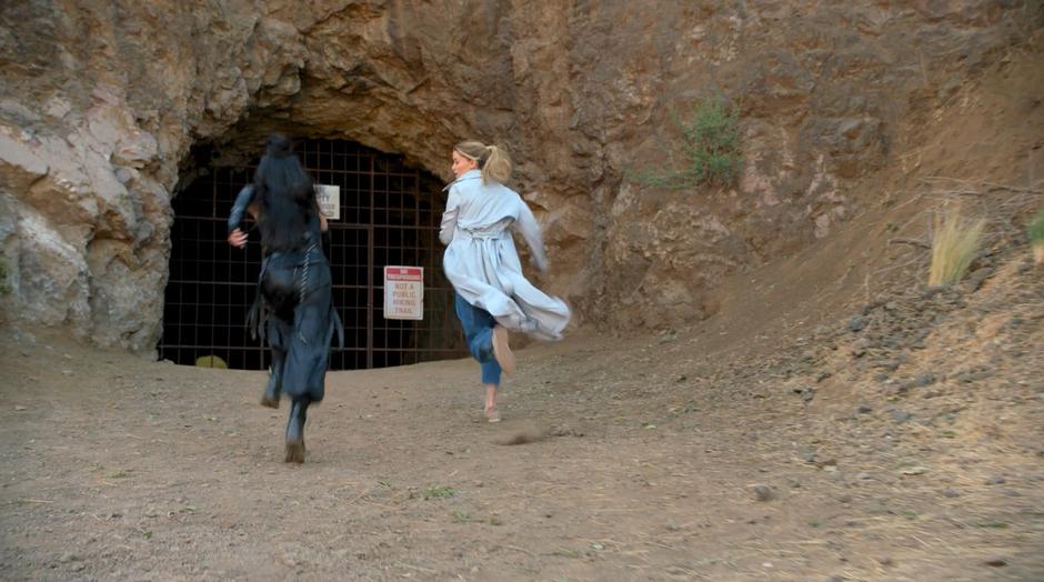 Nico and Karolina run towards the fence blocking the tunnel.