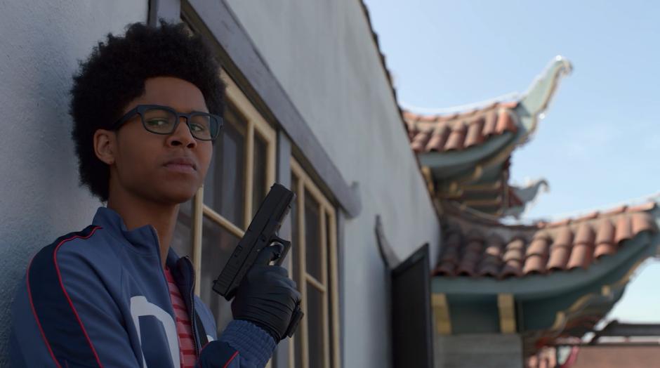 Alex stands on the roof holding up Darius's gun.