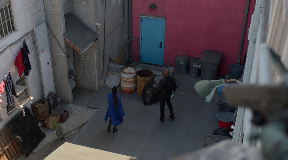 Catherine and Geoffrey search around the dead end alley for Alex while he holds out the gun above them.
