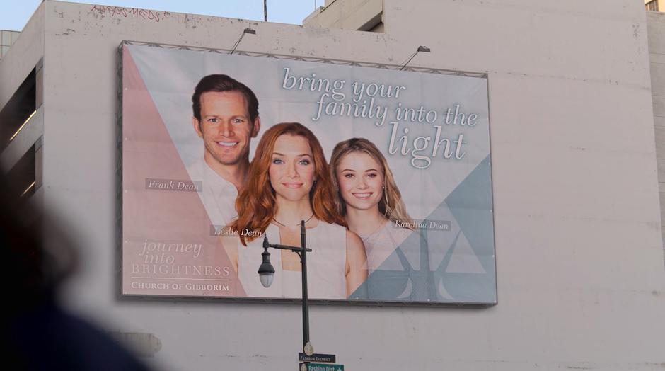 A billboard advertising the Church of Gibborim with Karolina and her family hangs on the side of a building.