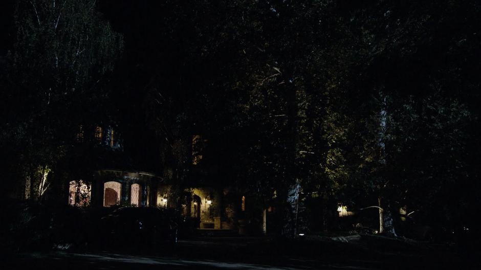 Establishing shot of the front of the mansion at night.