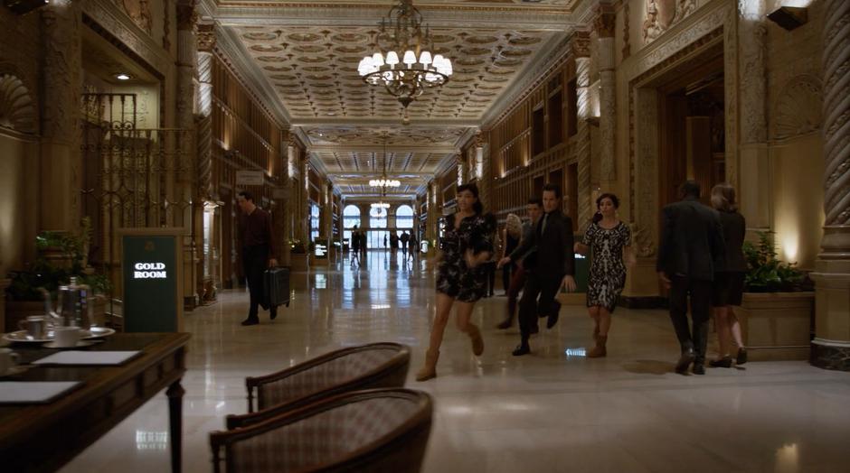 Cece, Schmidt, Benjamin, and Mimi rush towards Philip's desk to fill out the paperwork faster than the other couple.