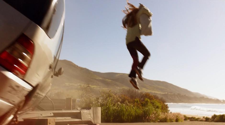 Young Kara jumps down from the crashed car with the baby in her arms.