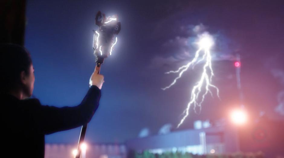 Joss Mardon holds up the staff to cause lightning to strike down at the facility.