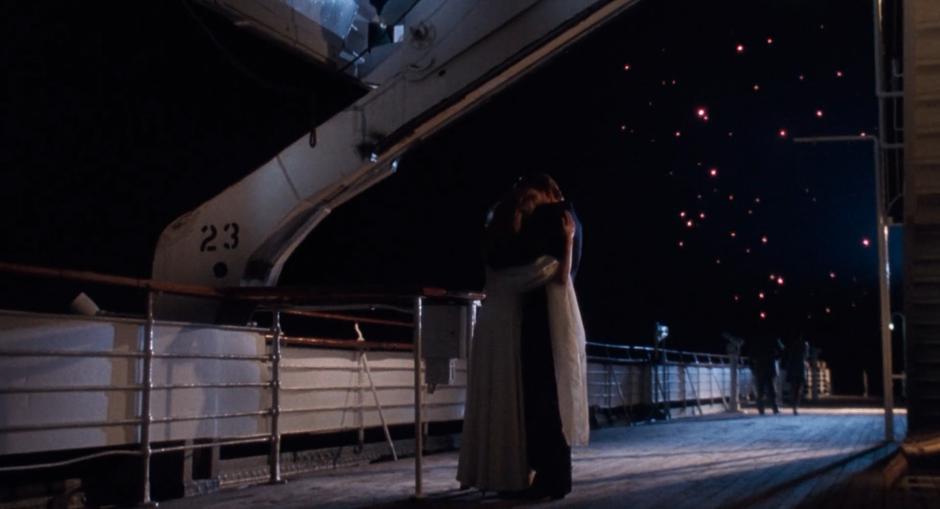 Liz and Nick kiss while standing under the fireworks on the deck of the ship.