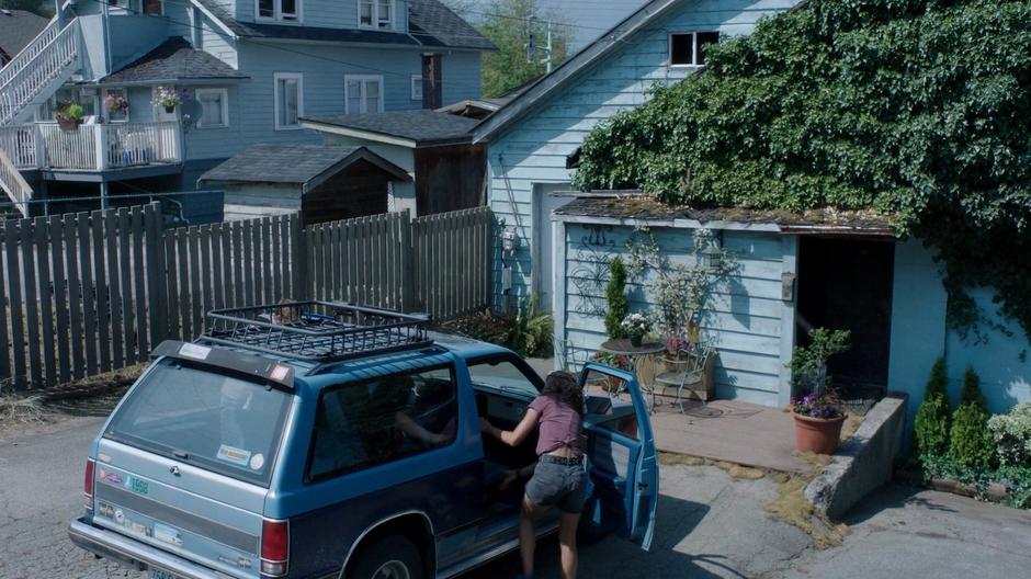 Maddie helps Ryn out of the car behind the store.