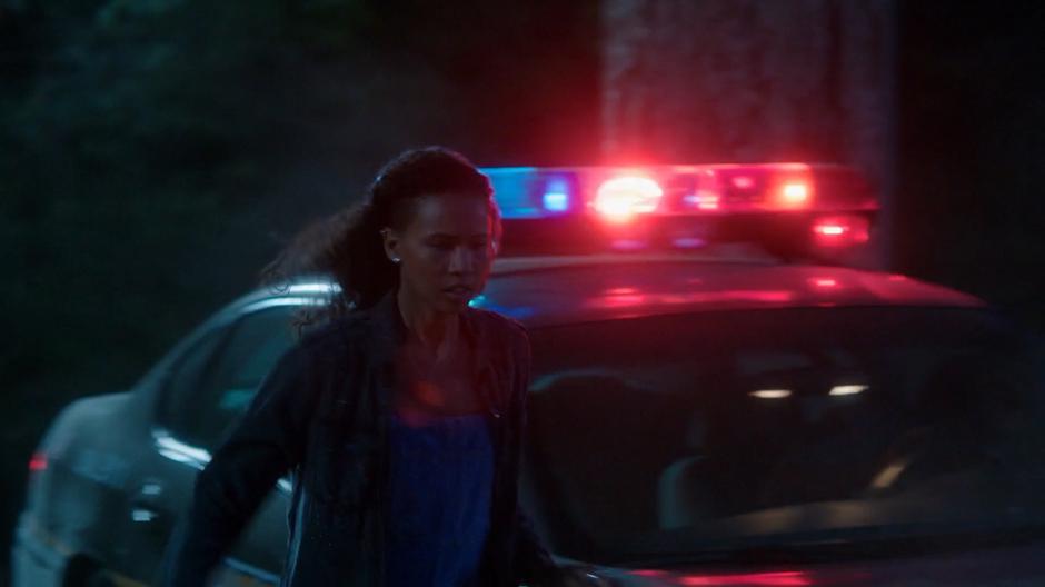 Maddie runs past a police car to the beach.