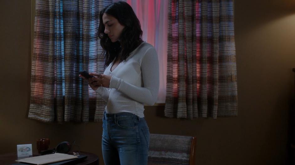 Nicole Martinez gets a text from Xander while standing in her room.