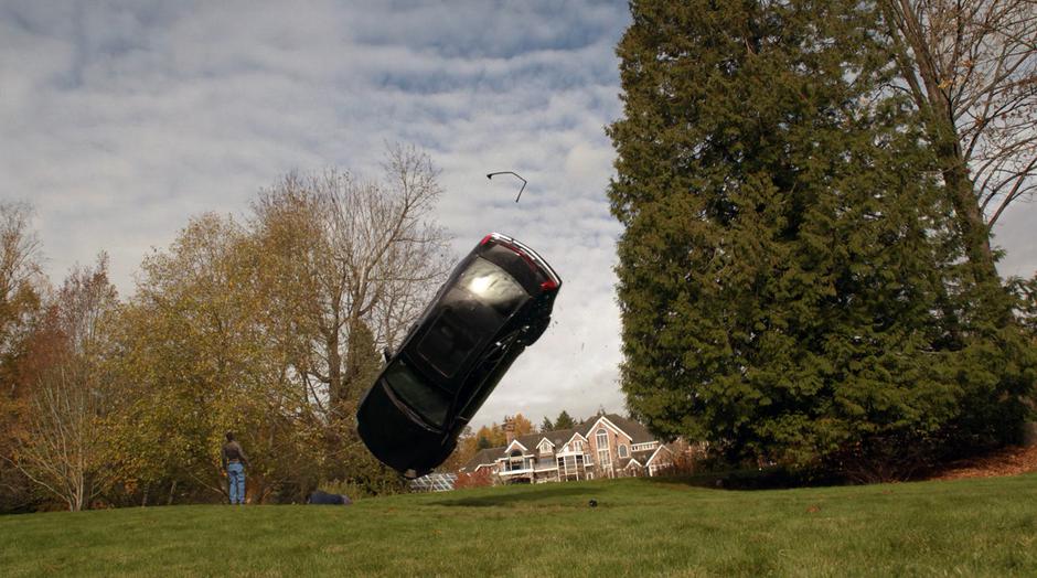 J'onn watches as General Tan's car flips over his unconscious body.