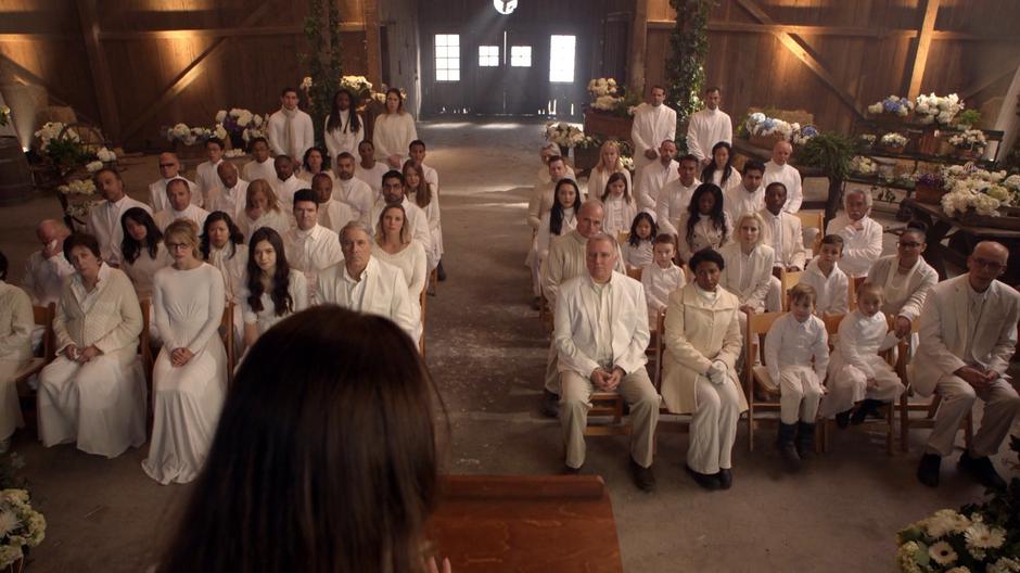 Kara, Nia, Paul, and the rest of the townspeople listen to Maeve's eulogy for her mother.