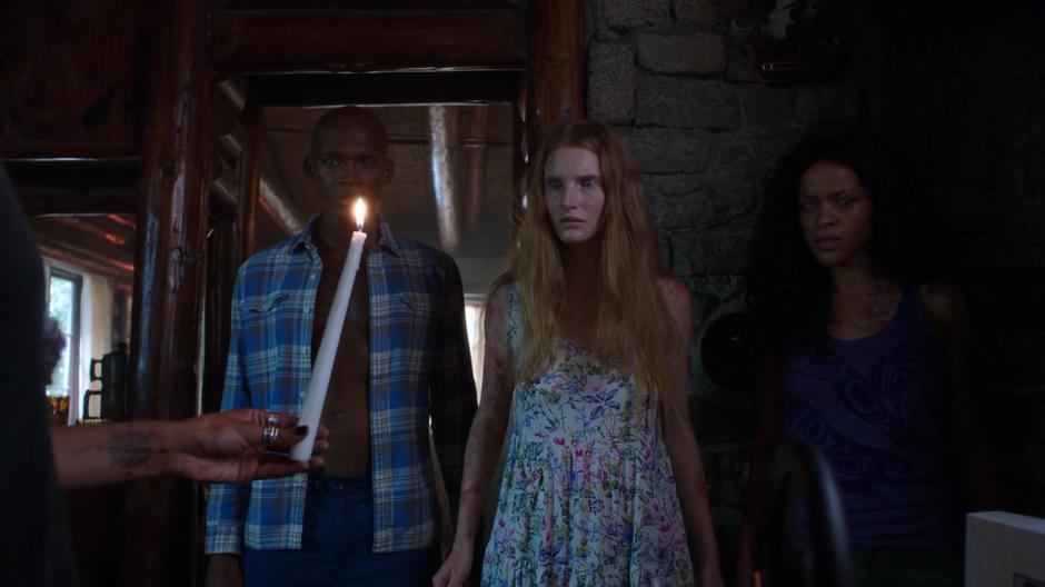 Maddie holds up the burning candle for three of the mermaids.
