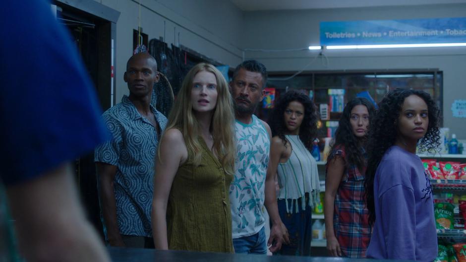 Six of the mermaids look over at the cashier after entering the convenience store.