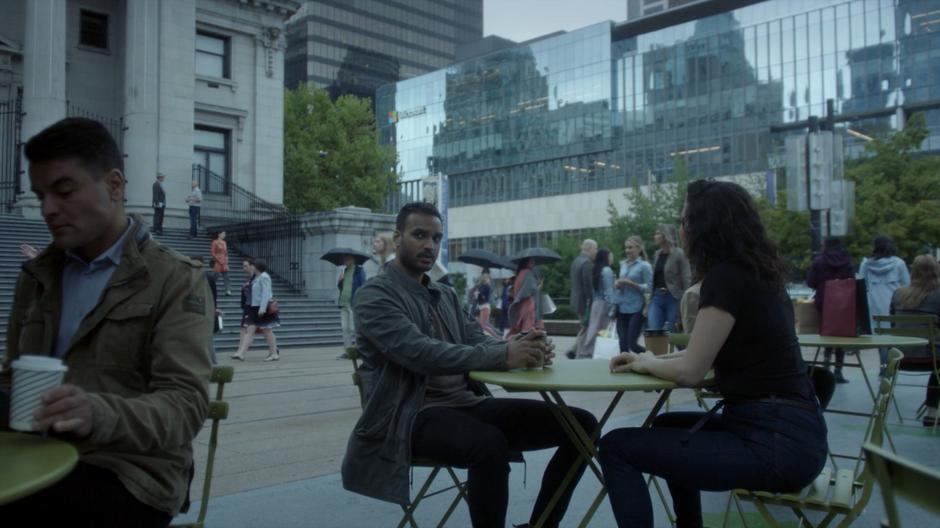 Penny and Kady talk while sitting at a table in the plaza.